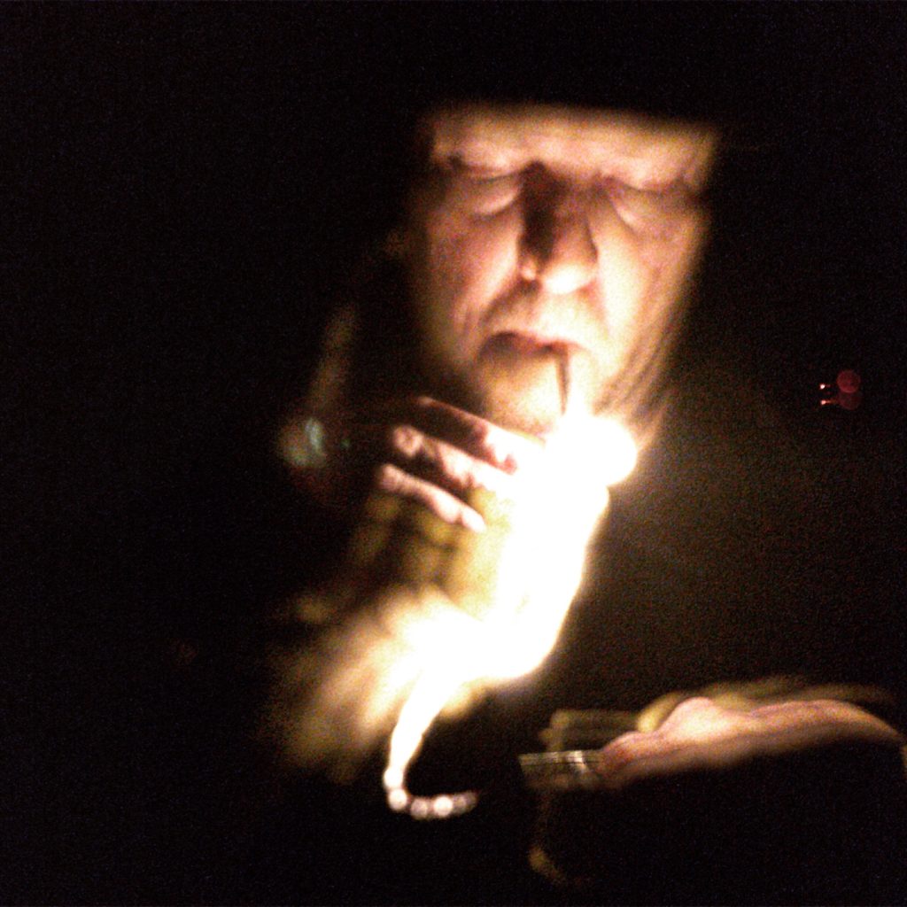 Low light image of lighting a cigarette with matches, with light trails turned on during capture.